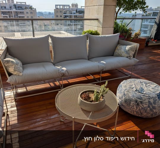 כריות ריפוד אפורות על ספה במרפסת עץ